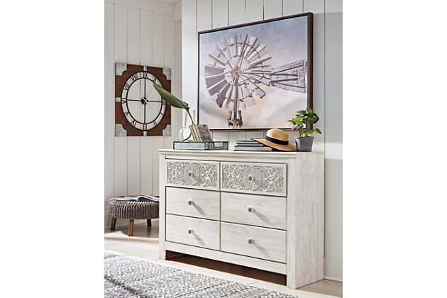 If it’s coastal chic or cottage quaint style you long for, the Paxberry whitewashed dresser invites you to go to town. Its distinctive weatherworn finish conveys an easy-breezy sensibility, perfect for a restful bedroom retreat. Tastefully edited lines and medallion drawer pulls give this attractively priced dresser a high-end aesthetic.Dresser only (mirror sold separately) | Made of engineered wood (MDF/particleboard) and decorative laminate | Whitewash replicated worn through paint with authentic touch | Hardware features a worn-through painted effect | 6 smooth-gliding drawers with faux laminate lining | Assembly required | Safety is a top priority, clothing storage units are designed to meet the most current standard for stability, ASTM F 2057 (ASTM International) | Drawers extend out to accommodate maximum access to drawer interior while maintaining safety