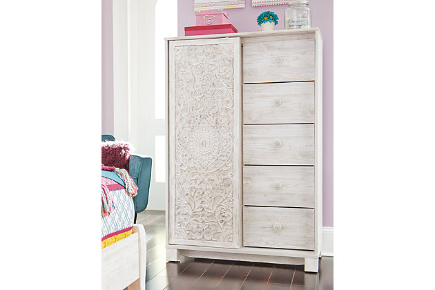 A one-of-a-kind girl deserves a bedroom retreat that celebrates her personal flair—and the Paxberry chest of drawers is so befitting. Wowing with an artful, carved-effect sliding door and richly distressed whitewash finish, this 5-drawer chest with additional shelved storage is packed with possibilities.Made of engineered wood (MDF/particleboard) and decorative laminate | Whitewash replicated worn through paint with authentic touch | 5 smooth-gliding drawers with faux laminate lining | Slider door revealing open storage with 3 adjustable shelves | Safety is a top priority, clothing storage units are designed to meet the most current standard for stability, ASTM F 2057 (ASTM International) | Drawers extend out to accommodate maximum access to drawer interior while maintaining safety