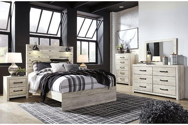 What a delightful take on rustic industrial style. Whether modern loft or modern farmhouse, the Cambeck queen panel bed makes itself at home. The wispy whitewash palette enhances without covering the grain for that weathered look you crave. Love to read in bed? You’re sure to find the retro-chic light sconces and USB plug-ins on the open-slat style headboard such a bright idea. Includes headboard, footboard and rails | Made of engineered wood (MDF/particleboard) and decorative laminate | Wispy white finish over replicated oak grain with authentic touch | 2 decorative sconce lights, LED with 3 AA batteries | 2 slim-profile USB charging ports | Power cord included; UL-listed | Foundation/box spring required, sold separately | Mattress available, sold separately | Assembly required | Estimated Assembly Time: 10 Minutes