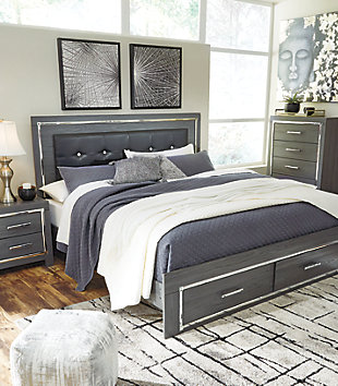 Reminiscent of Hollywood glamour of yesteryear, the Lodanna king panel bed with storage interprets luxury in a decidedly modern way. Sumptuous details include button-tufted upholstery, faceted faux crystals and chrome-tone accents beautifully lit by LED lights enhanced with remote-controlled settings for color and brightness.Includes headboard, storage footboard and side rails | Made of egineered wood (MDF/particleboard) and decorative laminate | Gray finish with replicated wood grain | Faux leather upholstery | Faux crystal and faceted chrome-tone metal accents | Accent LED lights with remote to control color and brightness | 2 smooth-operating drawers | Power cord included; UL Listed | Foundation/box spring required, sold separately | Mattress available, sold separately | Assembly required | Estimated Assembly Time: 10 Minutes