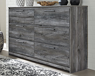 Beachy style and lots of storage go hand in hand with the Baystorm dresser. Its driftwood and surfer-inspired smoky finish creates a rustic look that's perfect for setting the scene of an island getaway. Six roomy drawers give you the space needed for stowing away clothes and more. Clean lines and modern handles provide an authentic look to be admired for years to come.Made of engineered wood and decorative laminate | Smoky gray finish over replicated oak grain with authentic touch | Linear pulls with antiqued gunmetal-tone finish | 6 smooth-gliding drawers | Drawer interiors are lined with a faux linen laminate for a clean, finished look | Safety is a top priority, clothing storage units are designed to meet the most current standard for stability, ASTM F 2057 (ASTM International) | Drawers extend out to accommodate maximum access to drawer interior while maintaining safety