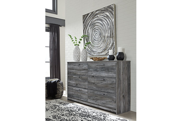 Beachy style and lots of storage go hand in hand with the Baystorm dresser. Its driftwood and surfer-inspired smoky finish creates a rustic look that's perfect for setting the scene of an island getaway. Six roomy drawers give you the space needed for stowing away clothes and more. Clean lines and modern handles provide an authentic look to be admired for years to come.Made of engineered wood and decorative laminate | Smoky gray finish over replicated oak grain with authentic touch | Linear pulls with antiqued gunmetal-tone finish | 6 smooth-gliding drawers | Drawer interiors are lined with a faux linen laminate for a clean, finished look | Safety is a top priority, clothing storage units are designed to meet the most current standard for stability, ASTM F 2057 (ASTM International) | Drawers extend out to accommodate maximum access to drawer interior while maintaining safety