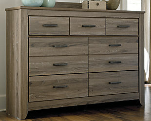 Urban sophistication with a decidedly relaxed air. If effortless elegance is the impression you’re going for, the Zelen dresser is custom made to fit your space. It’s got the crisp, clean lines of a contemporary piece, but with softly weathered elements, including antiqued industrial pulls and an earthy finish that lets the beauty of replicated oak grain flow through. Seven smooth-gliding drawers of varied size make it a bedroom essential.Dresser only | Made of engineered wood (MDF/particleboard) and decorative laminate | Warm gray vintage finish with white wax effect over replicated oak grain | Pewter-tone hardware | 7 smooth-operating drawers | Excluded from promotional discounts and coupons | Includes tipover restraint device | Safety is a top priority, clothing storage units are designed to meet the most current standard for stability, ASTM F 2057 (ASTM International) | Drawers extend out to accommodate maximum access to drawer interior while maintaining safety | Assembly required