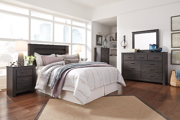 Priced to entice and styled to impress, the alluring Brinxton queen headboard is urban sophistication with a decidedly relaxed air. It’s got the crisp, clean lines of a contemporary piece, but with an earthy element. Deep, horizontal grooves infuse depth and dimension, while a replicated oak grain effect gives the charcoal gray finish warmth and character.Headboard only | Hardware not included | Made with engineered wood (MDF/particleboard) and decorative laminate | Dark charcoal finish over replicated oak grain | ¼" bolts are needed to attach headboard to existing bed frame | Bolt length depends on thickness of your bed frame | Assembly required