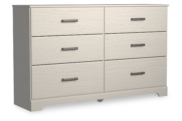 With its clean-lined look and modern attitude, the Stelsie dresser is a fresh style awakening. Crisp, white hue over subtle replicated wood grain easily complements other furniture finishes. Smooth drawer fronts with antiqued pewter-tone handles completes the aesthetic.Dresser only | Made with engineered wood (MDF/particleboard) and decorative laminate | White painted finish with subtle replicated wood grain with authentic touch | Antiqued pewter-tone handles | 6 smooth-gliding drawers | Safety is a top priority, clothing storage units are designed to meet the most current standard for stability, ASTM F 2057 (ASTM International) | Drawers extend out to accommodate maximum access to drawer interior while maintaining safety