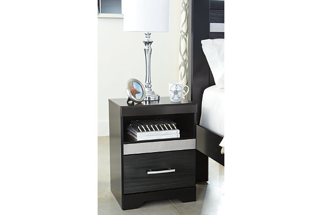 Starry, starry nights. Inspired by Hollywood glam, the richly styled Starberry nightstand steals the show in a simply stunning way. The nightstand’s replicated walnut grain is enriched with a high-gloss black finish, made even more dramatic with a strip of sleek silver glitter banding that accentuates a clean-lined, contemporary aesthetic. Discreetly positioned USB charging makes it all the more accommodating.Made of engineered wood (MDF/particleboard) and decorative laminate | High gloss black finish with replicated straight silver walnut grain framed in black finish | Silvertone glitter accent | Smooth-gliding drawer | Chrome-tone hardware with faux crystals | 2 slim-profile USB charging stations | Power cord included; UL Listed | Assembly required
