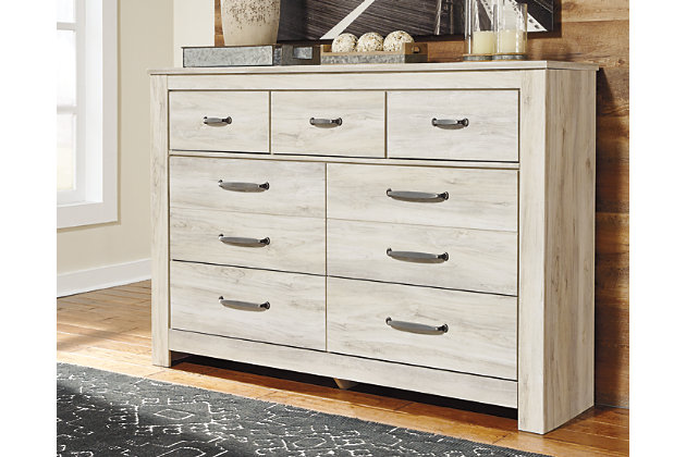 Gorgeous and modern, the Bellaby bed and dresser express your farmhouse style. Wispy white finish over replicated oak wood grain infuses so much character for a weathered, rustic look you’ll love. Clean-lined, classic panel styling provides a country-chic bedroom retreat that’s a breath of fresh air and provides the perfect foundation for an inviting space.Includes panel bed (headboard, footboard and rails) and 7-drawer dresser | Made of engineered wood (MDF/particleboard) and decorative laminate | Wispy white finish over replicated oak grain with authentic touch | Brushed nickel-tone hardware with black edging | Dresser with smooth-gliding drawers lined with faux linen laminate | Foundation/box spring required, sold separately; mattress available, sold separately | Safety is a top priority, clothing storage units are designed to meet the most current standard for stability, ASTM F 2057 (ASTM International) | Drawers extend out to accommodate maximum access to drawer interior while maintaining safety | Assembly required | Estimated Assembly Time: 10 Minutes