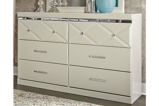 Love sleek and bold contemporary style? Live the dream with the Dreamur dresser. Eye-catching details include 3D pressed top drawers with beveled mirror banding. Faux crystal accented handles and knobs incorporate an added touch of sheen and shine.Dresser only | Made of engineered wood (MDF/particleboard) | Mirrored banding | Faux crystal hardware | 6 smooth-operating drawers | Includes tipover restraint device | Safety is a top priority, clothing storage units are designed to meet the most current standard for stability, ASTM F 2057 (ASTM International) | Drawers extend out to accommodate maximum access to drawer interior while maintaining safety