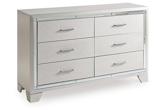Taking its cues from Hollywood Regency interiors, the Lonnix dresser is puttin’ on the ritz in a big way. The dresser’s ultra-clean profile is elevated with a spectacular metallic silvertone finish made all the more interesting with a hint of embossed texturing on the sleek, flush-mount drawers. The beveled mirror trimwork that frames the dresser creates a rich, reflective effect, while ultra-modern nickel-tone pulls with faux crystal insets serve as a fabulous finishing touch.Dresser only | Made of wood and engineered wood | Silvertone metallic finish | 6 smooth-gliding drawers with dovetail construction | Beveled mirror trim | Embossed, textural drawer fronts | Bright nickel-tone pulls with faux crystal insets | Includes tipover restraint device | Estimated Assembly Time: 30 Minutes