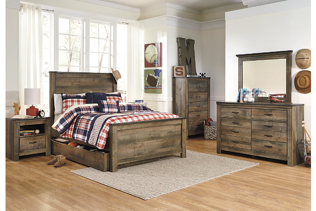 Whether she loves horses or he's a cowboy at heart, the Trinell chest of drawers matches their authenticity. Rustic finish, plank-style details and nailhead trim pay homage to reclaimed barn wood, making for a chic look loaded with charm. Five roomy drawers keep clothing or toys nicely reined in.Made of engineered wood (MDF/particleboard) and decorative laminate | Warm rustic plank finish over replicated oak grain and authentic touch | Antiqued bronze-tone hardware | 5 smooth-operating drawers | Nailhead accents | Safety is a top priority, clothing storage units are designed to meet the most current standard for stability, ASTM F 2057 (ASTM International) | Drawers extend out to accommodate maximum access to drawer interior while maintaining safety | Assembly required