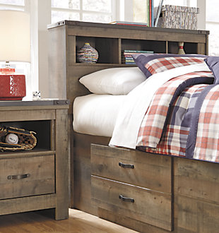 Whether she loves horses or he's a cowboy at heart, Trinell twin bookcase bed with under bed storage matches their authenticity. Rustic finish, plank-style details and nailhead trim pay homage to reclaimed barn wood, making for a chic look loaded with charm. Mattress available, sold separately.Includes bookcase headboard, footboard, under bed storage with side rail and slats | Made of engineered wood and decorative laminate | Warm rustic plank finish over replicated oak grain and authentic touch | 2 large storage drawers | Nailhead accents | Bed does not required a foundation/box spring | Mattress available, sold separately | Assembly required | Estimated Assembly Time: 30 Minutes