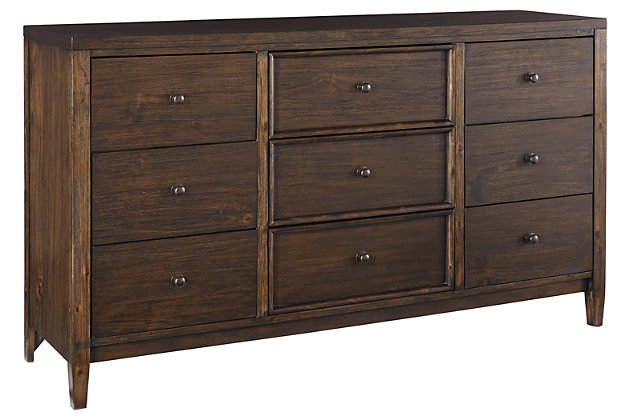If you’re longing for just the right blend of high-style contemporary and mid-century minimalism, the Kisper dresser rises to the occasion. A mastery in simplicity, this dresser is ready to impress with a brushed dry-brown wood finish that’s wonderfully complex. Framed drawer accents and a wire-brushed texture give this richly veneered piece added interest. “Off-the-floor” design beautifully elevates the mood.Dresser only | Made of wood, veneers and engineered wood | Brushed dry-brown wood finish | Wire-brushed texture | 9 smooth-gliding drawers with dovetail construction (top drawers felt lined) | Includes tipover restraint device | Estimated Assembly Time: 15 Minutes