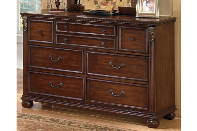 If you love the look of traditional design, then the Leahlyn dresser may be the one for you. Pilaster and acanthus accents and antiqued brass-tone bail pulls and knobs are all hallmarks of European styling in your newfound classic.Dresser only | Made of veneers, wood, engineered wood and cast resin | Metallic finish accents | Antiqued brass-tone hardware | 7 drawers with dovetail construction | Top drawers with felt bottoms | Bun feet | Minor assembly required | Estimated Assembly Time: 15 Minutes