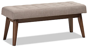 What a striking choice for mid-century modern and fashion-forward spaces. Sumptuously cushioned upholstered bench in light gray is sure to make a high-style addition to your home. Fabulous in an entryway or under a window, it’s equally at home at the foot of the bed.Made of wood | Light gray polyester upholstery | High-density foam cushioning | Button-tufted seat | Walnut-tone legs | Some assembly required