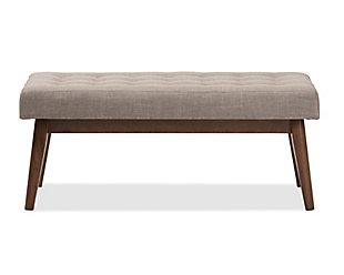 What a striking choice for mid-century modern and fashion-forward spaces. Sumptuously cushioned upholstered bench in light gray is sure to make a high-style addition to your home. Fabulous in an entryway or under a window, it’s equally at home at the foot of the bed.Made of wood | Light gray polyester upholstery | High-density foam cushioning | Button-tufted seat | Walnut-tone legs | Some assembly required