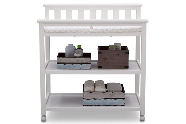 The Flat Top Changing Table with Wheels from Delta Children grants you the freedom to easily change and dress your baby. A convenient changing station, this versatile table has a flat back with slated detailing and a streamlined profile that effortlessly pairs with any item. Outfitted with two fixed shelves to conveniently store your child's essential items, the Flat Top Changing Table also features four casters on the bottom, so you can roll the table from one end of the room to the other. For your baby’s safety, the included changing pad with safety strap keeps your little one secure—even when they won’t stay still.For any questions regarding delta children products, please contact consumersupport@deltachildren.com monday to friday, 8:30 a.m. To 6 p.m. (est) | Made of wood, engineered wood and metal | Strong and sturdy wood construction | Includes two fixed shelves for open storage | Changing pad with safety strap included | Assembly required
