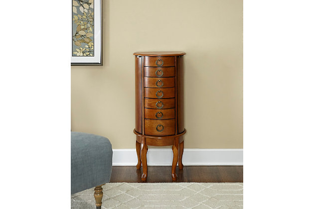 With all the allure of a treasured heirloom—at a fraction of the price—this beguiling jewelry armoire will fit right in. Early American touches such as open ring pulls, Queen Anne feet and plentiful accessory drawers entice, while the rich, burnished oak-tone finish and lift-top mirror are clear reflections of your good taste.Made of rubberwood, veneer and engineered wood | Burnished oak-tone finish | Plush black rayon lining | 6 spacious drawers | 2 concealed side storage cabinets | Lift top storage space with mirror | Circular knobs | Assembly required