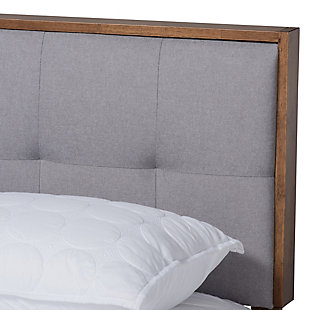 Create the chic, modern bedroom of your dreams with this bed. Built with a sturdy wood frame, it features a low platform finished in a warm walnut-tone. The headboard is upholstered in a soft, foam-filled fabric set within a wooden frame for a tailored look. Biscuit tufting lends dimension and elegance, while splayed legs create a cool, retro profile.Made of wood and engineered wood | Polyester upholstered headboard with button tufting | Brown walnut-tone finish | Mattress  available, sold separately | Assembly required | Slats eliminate the need for a box spring