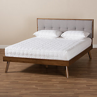 Create the chic, modern bedroom of your dreams with this bed. Built with a sturdy wood frame, it features a low platform finished in a warm walnut-tone. The headboard is upholstered in a soft, foam-filled fabric set within a wooden frame for a tailored look. Biscuit tufting lends dimension and elegance, while splayed legs create a cool, retro profile.Made of wood and engineered wood | Polyester upholstered headboard with button tufting | Brown walnut-tone finish | Mattress  available, sold separately | Assembly required | Slats eliminate the need for a box spring