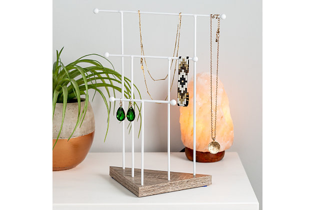 Your favorite necklaces, bracelets and earrings keep you looking so good, but when it's time to take them off for the night you never have anywhere put them. This jewelry stand offers 3 hang bars where you can securely store all your favorite jewelry. That necklace of your grandma's that makes you feel oh so good just to look at now has an appropriate place to call home.3 staggered hang bars for jewelry storage | Ball bearings keep jewelry secure | Geo-shaped base with natural wood finish | Powder-coated matte white for modern look