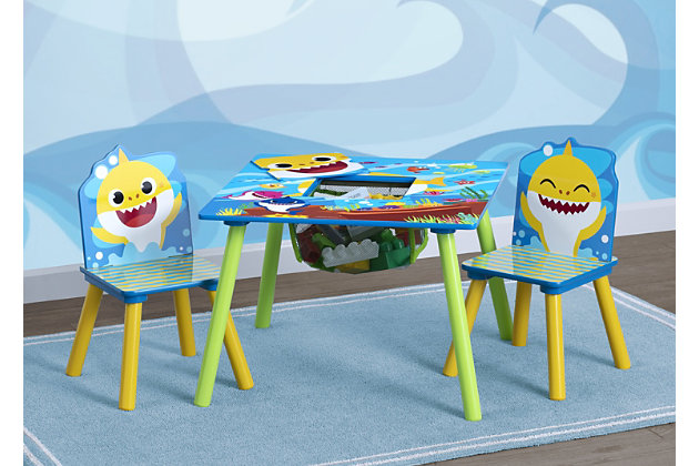 You’ve heard the Baby Shark song... now you can bring the Baby Shark family into your home this Baby Shark Kids Table and Chair Set with Storage by Delta Children. Featuring character graphics of Baby Shark, Mommy Shark, Daddy Shark, Grandma Shark and Grandpa Shark, this table and chair set is totally jaw dropping. Making any activity extra-special, this kids table and chair set features a table and two chairs, designed at the perfect kid-sized height, making it ideal for snack time, playtime or homework. Plus, a built-in storage compartment at the center of the table provides the perfect space to keep art supplies. About Baby Shark: Baby Shark and his best friend William take fun-filled comedic adventures in their community of Carnivore Cove, meeting new friends and singing catchy tunes along the way. Baby shark, doo, doo, doo, doo, doo, doo.What's included: set includes one table and two chairs; table features handy toy keep in the center for easy storage | Age range: recommended for toddlers and kids ages 3+; each chair holds up to 50 lbs. | For baby shark fans: this set features fun and colorful graphics of baby shark, mommy shark, daddy shark, grandma shark and grandpa shark | Durable construction: made of engineered wood and solid wood; scratch-resistant finish protects the table's colorful graphics; easy assembly | Size: assembled dimensions: 24"l x 24"w x 17.72"h