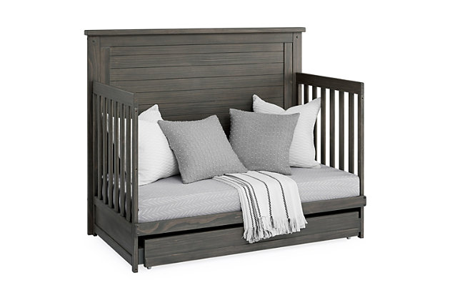 The Caden 6-in-1 Convertible Crib with Trundle Drawer by Simmons Kids is designed with lasting, farmhouse style. The crib's softy textured finish is hand-applied for a rustic look while the included trundle drawer adds additional functionality with space to store extra blankets and other bed linens. Plus, it will accommodate your baby from birth through their teenage years. This crib's grow-with-me design features three adjustable height levels that allow the crib to be lowered as your child begins to stand, and it converts from a crib to a toddler bed, sofa, daybed and size bed with headboard and footboard or headboard only. Available in Rustic gray, Rustic Mist and Rustic Acorn. Daybed Rail and Trundle included; Toddler Guardrail, Size Bed Rails sold separately. Producing the finest furniture for over 80 years, Simmons Kids has always been committed to the safety of every family. All Simmons Kids cribs are JPMA certified, are rigorously tested to meet or exceed all industry safety standards.SAFE OPTION FOR YOUR BABY: This crib is JPMA certified to meet or exceed all safety standards set by the CPSC and ASTM. We know chemicals have no place in your nursery, so we use a non-toxic multi-step painting process that is lead and phthalate safe | 6-IN-1 CONVERTIBLE CRIB WITH TRUNDLE: Crib converts to a toddler bed, daybed, sofa, bed with headboard and footboard and to a bed with headboard only (Daybed rail included). Included under crib trundle storage drawer features 4 wheels for easy operation | FARMHOUSE FINISH: Crib is available in Rustic gray, Rustic Mist or Rustic Acorn. The softy textured finish is hand applied. Due to varying grains and natural variations in the wood, no two pieces are exactly alike | ADJUSTABLE HEIGHT: Adjustable height mattress support with 3 convenient positions to grow with your baby. ACCESS RAIL DIMENSIONS: From Floor: 36.25"; From Top Mattress Support Position: 17.5"; From Bottom Mattress Support Position: 27.75" | COORDINATING ITEMS: Pair with any Delta Children Dresser in the same color, for the perfect baby nursery. Uses a standard size crib mattress (sold separately). To ensure the perfect fit pair your crib with a Delta Children, Serta, Beautyrest or Simmons Kids crib mattress