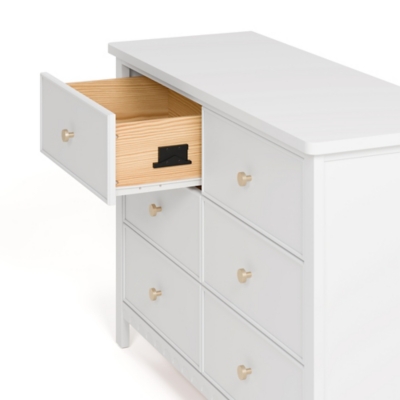 Open drawer showing interior wood, part of dresser with white exterior