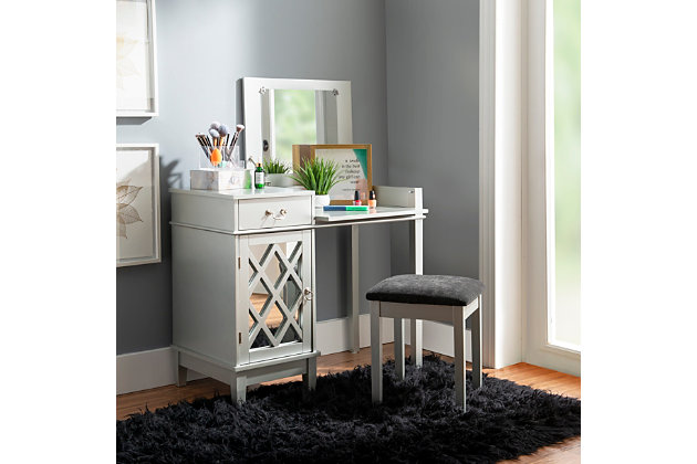 Sporting a metallic silvertone finish with mirrored accents and a flip-top design, the Lattice vanity set has a look girls of every age flip for. Along with hidden storage under the vanity’s divided top, a smooth-gliding drawer and generous cabinet make room for an abundance of beauty essentials. Perfect for a teen’s room, this vanity set is sure to give your “you” space a welcome touch of glitz and glam.Made of wood and engineered wood | Silvertone finish | Flip top with safety hinge reveals mirror and open storage | Flip-down front panel for added surface space | Single drawer with silvertone metal pull | Storage cabinet with lattice mirrored decorative door | Cutout for wire management | Ca fire foam padded seat with black microfiber upholstery | Assembly required