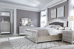 Coralayne queen bed allures with the glitz and glam befitting silver screen queens. Exquisite frame's metallic tone channels that Hollywood Regency flair you've been dreaming of. Button-tufted fabric inlay will have you feeling sheltered in comfort and luxury. Mattress and foundation/box spring sold separately.Made of veneers, wood and engineered wood | Includes headboard, footboard and rails | Metallic sheen finish | Button-tufted polyester upholstery | Assembly required | Foundation/box spring required, sold separately | Mattress available, sold separately | Estimated Assembly Time: 70 Minutes