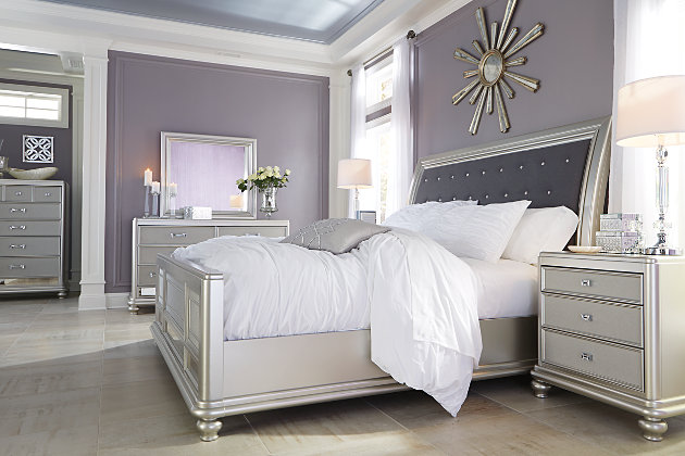 Coralayne California king sleigh bed allures with the glitz and glam befitting silver screen queens. Exquisite frame's metallic tone channels that Hollywood Regency flair you've been dreaming of. Fabric inlay with crystal-look button tufting will have you feeling sheltered in comfort and luxury. Mattress and foundation/box spring available, sold separately.Made of solid wood and engineered wood | Includes headboard, footboard and rails | Metallic sheen finish | Crystal-look button tufted polyester upholstery | Assembly required | Foundation/box spring required, sold separately | Mattress available, sold separately | Estimated Assembly Time: 40 Minutes