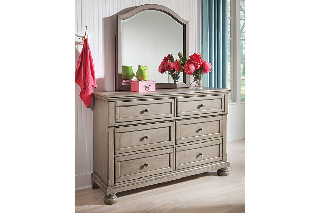 Satisfying your taste for tradition, the Lettner dresser and mirror set sports serene sophistication. Forever classic design details—inlaid panels, silvertone patina hardware and bun feet—are so easy to love. Six roomy drawers keep your wardrobe organized in style. Beveled mirror frame beautifully echoes the dresser’s burnished light gray finish for modern sensibility.
Made of veneers, wood and engineered wood | Silvertone patina hardware | 6 smooth-gliding drawers with dovetail construction | Top drawers felt-lined | Mirror attaches to back of dresser | Assembly required | Estimated Assembly Time: 35 Minutes