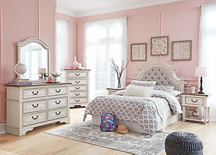 Elevating the art of traditional cottage styling, the Realyn dresser is her dream bedroom retreat realized. Antiqued two-tone aesthetic blends a chipped white with a distressed wood finished top for added charm. Framed drawer fronts and decorative corbels add refinement, while bail pulls in a dark bronze-tone finish lend a classic touch.Dresser only | Made of veneers, wood and engineered wood, with cast resin components | Antiqued two-tone finish | 6 smooth-gliding drawers with dovetail construction (top drawers felt lined) | Dark bronze-tone finished metal hardware | Estimated Assembly Time: 15 Minutes