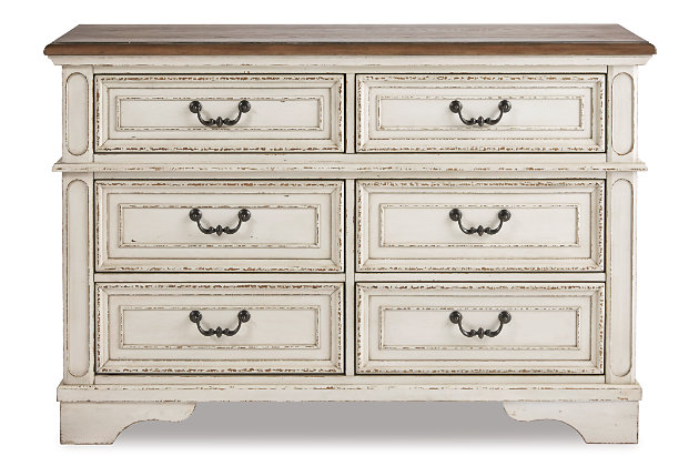 Elevating the art of traditional cottage styling, the Realyn dresser is her dream bedroom retreat realized. Antiqued two-tone aesthetic blends a chipped white with a distressed wood finished top for added charm. Framed drawer fronts and decorative corbels add refinement, while bail pulls in a dark bronze-tone finish lend a classic touch.Dresser only | Made of veneers, wood and engineered wood, with cast resin components | Antiqued two-tone finish | 6 smooth-gliding drawers with dovetail construction (top drawers felt lined) | Dark bronze-tone finished metal hardware | Estimated Assembly Time: 15 Minutes