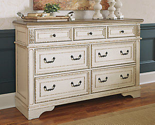Elevating the art of traditional cottage styling, the Realyn bed and dresser is your dream bedroom retreat realized. Affording curvaceous beauty, the brilliant crafting of this set wows with dramatic scalloped details. The distressed white finish complements both the tufted upholstery on the headboard and the two-tone aesthetic on the dresser for heirloom appeal. Create the cottage bedroom you’ve always wanted with the Realyn bedroom set.Includes upholstered headboard, footboard, rails and dresser | Made of veneer, wood and engineered wood, with cast resin components  | Polyester upholstered headboard with foam cushion and button tufting | Dresser only | Distressed, chipped white finish  | Dark bronze-tone hardware | 7 smooth-gliding drawers with dovetail construction | Distressed wood top on dresser  | Assembly required | Foundation/box spring required, sold separately | Mattress available, sold separately | Estimated Assembly Time: 85 Minutes