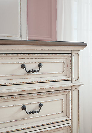 Elevating the art of traditional cottage styling, the Realyn dresser and mirror set is your dream bedroom retreat realized. This brilliantly crafted bedroom ensemble wows with dramatic scalloped details and an antiqued two-tone aesthetic blending a chipped white with a distressed wood finished top for added charm. Framed drawer fronts and decorative corbels add refinement, while bail pulls in a dark bronze-tone finish lend a classic touch.Made of veneers, wood and engineered wood, with cast resin components | Antiqued two-tone finish | 6 smooth-gliding drawers with dovetail construction | Dark bronze-tone hardware | Mirror attaches to back of dresser | Assembly required | Includes tipover restraint device | Estimated Assembly Time: 35 Minutes