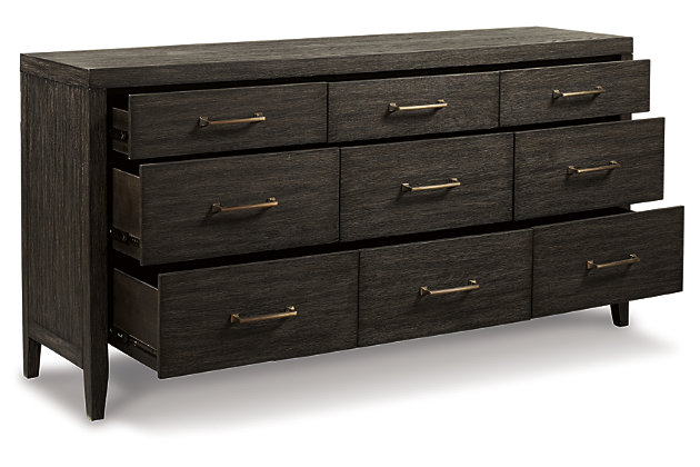 Few pieces demand attention like the Bellvern dresser. Those drawn to the earthy character of the wire-brushed texture—with a complex, multi-layered finish—can appreciate the beauty and craftsmanship of this bedroom essential. In addition to its acacia wood and oak veneer construction, clean contemporary lines and simple symmetry have a minimalist appeal that fits perfectly in an upscale transitional setting.Dresser only | Made of acacia wood, oak veneer and engineered wood | Blackened effect finish with contrasting gray undertones and wire-brushed texture | Antiqued bronze-tone hardware | 9 smooth-gliding drawers with dovetail construction | Top drawers felt-lined | Assembly required | Estimated Assembly Time: 30 Minutes