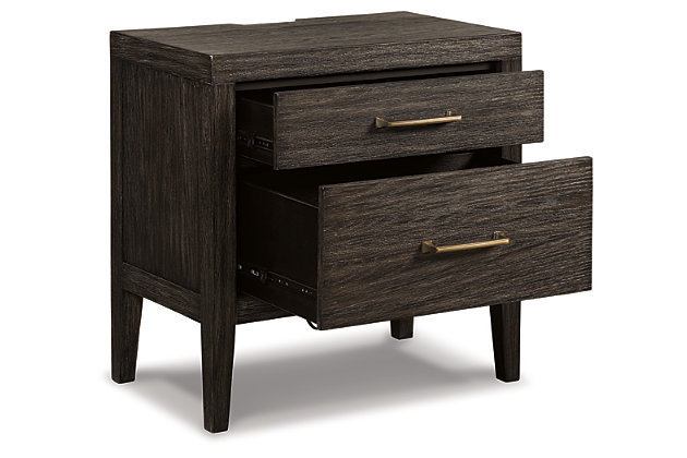Few pieces demand attention like the Bellvern nightstand. Those drawn to the earthy character of the wire-brushed texture—with a complex, multi-layered finish—can appreciate the beauty and craftsmanship of this bedroom essential. In addition to its acacia wood and oak veneer construction, clean contemporary lines and simple symmetry have a minimalist appeal that fits perfectly in an upscale transitional setting.Made of acacia wood, oak veneer and engineered wood | Blackened effect finish with contrasting gray undertones and wire-brushed texture | Antiqued bronze-tone hardware | 2 smooth-gliding drawers with dovetail construction | Top drawer felt-lined | 2 electrical outlets and 2 USB charging stations | Power cord included; UL Listed | Assembly required | Estimated Assembly Time: 15 Minutes
