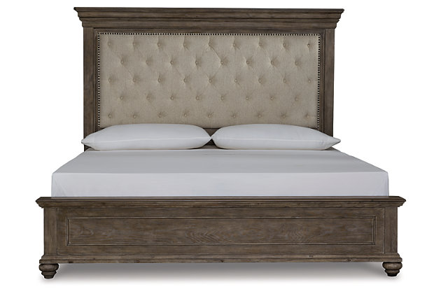 Homey. Hearty. Heavenly hued. Luring with a distressed weathered gray finish, substantial mouldings and a tall mansion-style headboard with great presence, the Johnelle queen upholstered bed is sure to make your homestead feel that much more like home. The look is beautified with elm veneers for a richly crafted master suite masterpiece made for years of satisfaction. Inset headboard cushion with tufted upholstery and dark pewter-tone nailhead trim adds comfort and a sense of indulgence. Whether your aesthetic is classic, eclectic or modern farmhouse, rest assured, this high-style, high-quality queen upholstered bed is an inspired choice. Mattress and foundation/box spring available, sold separately.Made of elm veneers, acacia wood and engineered wood | Includes upholstered headboard, footboard and rails | Distressed weathered gray finish | Polyester upholstery with dark pewter-tone nailhead trim | Assembly required | Foundation/box spring required, sold separately | Mattress available, sold separately | Estimated Assembly Time: 55 Minutes