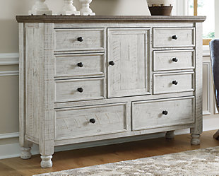 What a fresh interpretation of country classic style. Inspired by American farmhouse craftsmanship, but with an elevated sensibility, the Havalance dresser blends distinctive details such as turned post accents and raised drawer fronts for a substantial look that feels right at home. Those who appreciate rustic character should take note of this dresser’s thick profile crown moulding and stylish center cabinet, beautified with a vintage two-tone finish.Dresser only | Made of pine wood, pine veneer and engineered wood | Two-tone finish; distressed weathered gray top with distressed vintage white base | Antiqued iron-tone hardware | 8 smooth-gliding drawers with dovetail construction | Center cabinet with adjustable shelf | Top drawers with felt lining | Includes tipover restraint device | Assembly required | Estimated Assembly Time: 15 Minutes