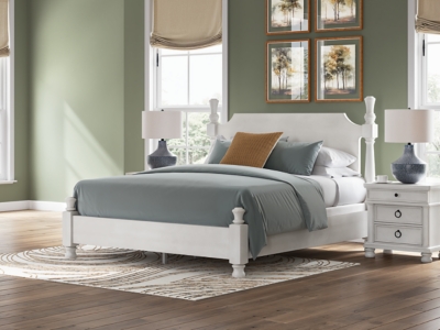White wooden nightstand shown from side with rounded feet
