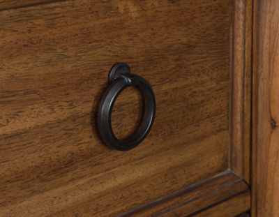 Close-up of circular metal ring pull on a wooden drawer