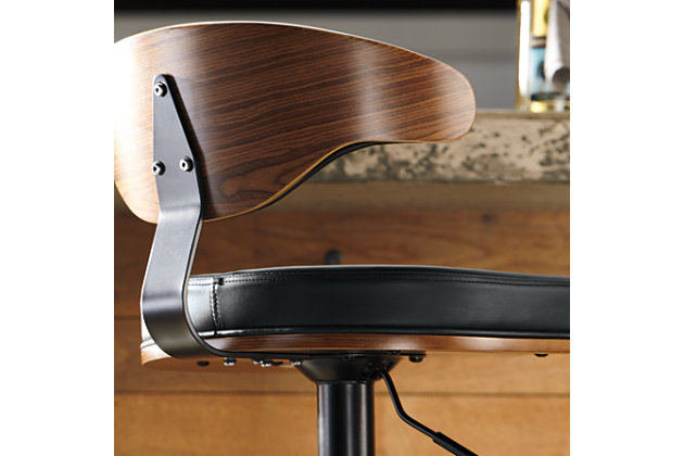 Style takes quite a modern turn. Sporting a distinctively contoured back, this upholstered swivel bar stool is sure to bring an elevated look to your living space. Wrapped in a black faux leather upholstery, the seating area’s artful contours put the accent on comfort.360-degree swivel | Matte black tubular metal base | Cushioned seat with black faux leather upholstery | Adjustable height (moves from counter to pub height) | Footrest and weighted pedestal base | Assembly required | Excluded from promotional discounts and coupons | Estimated Assembly Time: 15 Minutes