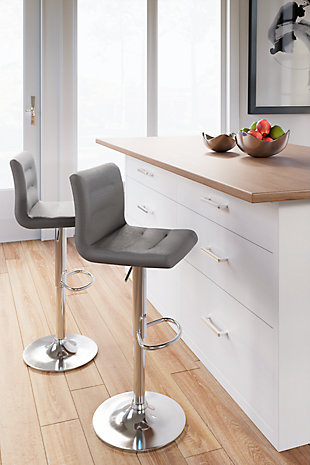 Have a taste for highly contemporary style? You’re sure to find the posh and polished Pollzen bar stool something to savor. Crafted with a sturdy steel frame beautified with a brilliant chrome-tone finish, this designer bar stool caters to your comfort with an adjustable height feature and swivel pedestal base. The cushioned seat and backrest are covered in a feel-good stone color upholstery with channeled details that enhance its modern appeal.Sturdy steel frame in chrome-tone finish | Stone color woven polyester upholstery over foam cushioned seat | Channel stitched details | Swivel pedestal base | Adjustable height | Comfortable footrest | Assembly required | Estimated Assembly Time: 30 Minutes