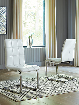 Wowing with a slim but sturdy profile and sculptural C-frame design, the Madanere dining room upholstered chair is sure to whet your appetite for ultra-contemporary style. Comfortably contoured seat is covered in a fabulous white faux leather with subtle grid tufting. Metal frame’s chrome-tone finish contrasts with a high-sheen effect.Metal frame in chrome-tone finish | Cushioned seat with grid tufting | Polyurethane upholstery | Assembly required | Estimated Assembly Time: 15 Minutes