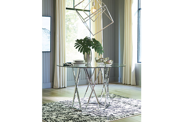 Wowing with an open and airy but sturdy profile, the Madanere round dining room table is sure to whet your appetite for ultra-contemporary style. Sporting a chrome-tone finish for a high-sheen effect, the hexagonal metal base is striking from every angle. Clear glass top rounds out the look with sheer simplicity.Metal frame in chrome-tone finish | Clear, tempered glass top with beveled edge | Seats 4 | Assembly required | Estimated Assembly Time: 30 Minutes