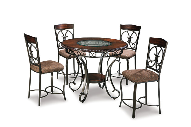 Incorporating a touch of European influence with its scrolled metal accents, the Glambrey 5-piece dining room set mixes various textural elements and rich earth tones in a way that’s so pleasing to the palette. The circular inset glass on the dark finished tabletop serves up light and airy contrast. Whether you’re looking to entertain or simply make the best of your nest, do it with flair.Includes counter-height dining table and 4 counter-height bar stools | Table seats up to 4 | Made of metal, veneers and engineered wood | Hand-finished | Inset glass tabletop | Table with 1 fixed shelf | Base with powder coated finish | Dark cherry-color wood | Dark bronze-tone metal | Chairs with polyester upholstery over foam cushion | Assembly required | Estimated Assembly Time: 60 Minutes