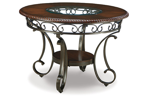 Incorporating a touch of European influence with its scrolled metal accents, the Glambrey dining room table mixes various textural elements and rich earth tones in a way that’s so pleasing to the palette. We love how the circular inset glass on the dark finished tabletop serves up light and airy contrast. Whether you’re looking to entertain or simply make the best of your nest, do it with flair.Seats up to 4 | Hand-finished | Assembly required | Made of metal, veneers and engineered wood | Inset glass tabletop | Base with powder coated finish; dark cherry-color accent tabletop | Excluded from promotional discounts and coupons | Dining chairs sold separately | Estimated Assembly Time: 30 Minutes
