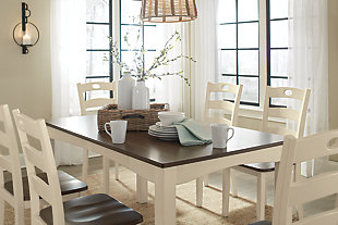 Turn your eat-in kitchen or dining room into a cottage-chic retreat with the Woodanville dining room table set. Distinctive elements include a two-tone finish for a double helping of charm and shapely arched aprons. Six pierced ladderback dining chairs are a classic complement.Includes dining room table and 6 dining room chairs | Made of veneers, wood and engineered wood | Two-tone finish | Estimated Assembly Time: 90 Minutes