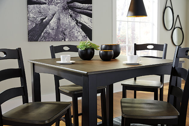 With its unique blend of soft black with grayish brown, the Froshburg 5-piece square counter height table set serves up cottage-chic style with sophistication. Four pierced ladderback bar stools elevate a classically charming scene that’s sure to satisfy for years to come.Includes counter height table and 4 bar stools | Made of veneers, wood and engineered wood | Two-tone finish | Assembly required | Estimated Assembly Time: 90 Minutes