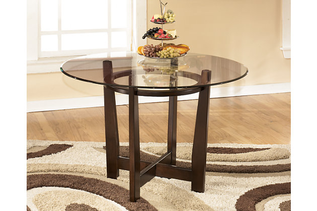 Dinner and a show are best served from the Charrell dining table. Thick beveled glass shows off the table's unique intersectioned base. Envision it in a dining room, kitchen or family game room.Assembly required | Made of veneers, wood, engineered wood and glass | Clear glass tabletop | Dining chairs sold separately | Estimated Assembly Time: 15 Minutes
